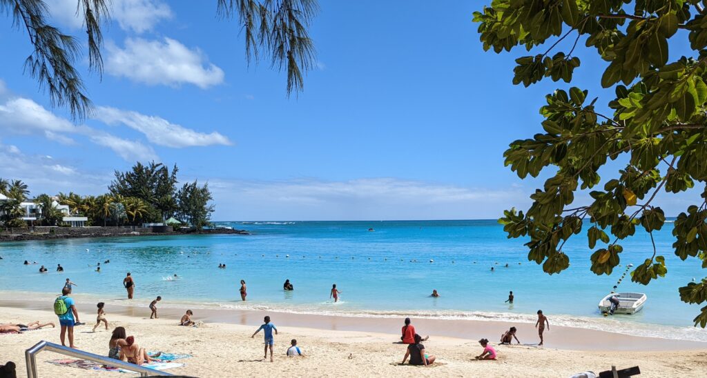 Pereybère beach seen from the steps, with the red swimming buoys and the reef line on the horizon